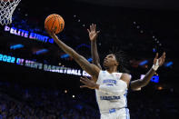 FILE - North Carolina's Caleb Love goes up for a shot past St. Peter's Clarence Rupert during the first half of a game in the NCAA men's college basketball tournament March 27, 2022, in Philadelphia. “We kind of want to write our own story,” Love said. “This is a new team. This is a new age. For us to go out this year and do what we've got to do, knowing what happened last year, we're more motivated than ever.” (AP Photo/Chris Szagola, File)