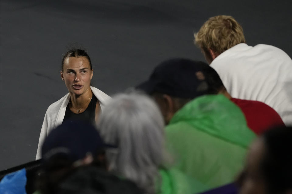 Aryna Sabalenka, of Belarus, speaks with her coach during a pause due to rain, at a women's singles semifinal match against Iga Swiatek, of Poland, at the WTA Finals tennis championships, in Cancun , Mexico, Saturday, Nov. 4, 2023. (AP Photo/Fernando Llano)