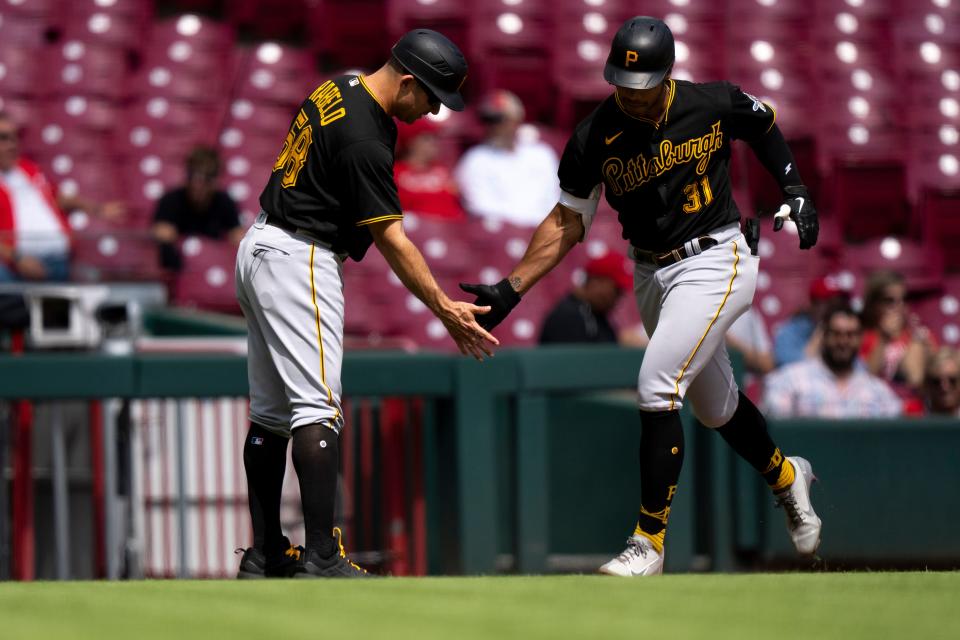 Pittsburgh right fielder Cal Mitchell (31) high fives Pittsburgh Pirates third base coach Mike Rabelo (58) after hitting a 2-run home run in the sixth inning against the Cincinnati Reds Tuesday.