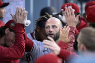 Arizona Diamondbacks' Christian Walker is congratulated by teammates in the dugout after hitting a solo home run during the second inning of a baseball game against the Los Angeles Dodgers Saturday, April 1, 2023, in Los Angeles. (AP Photo/Mark J. Terrill)