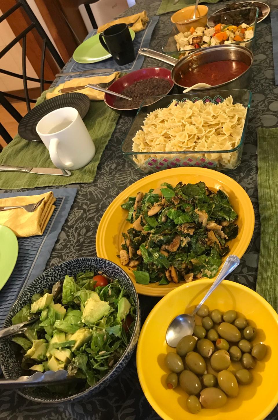 A satisfying spread of garlic- and pimiento-stuffed green olives; a fresh salad with greens, avocado and cherry tomatoes; collards and butter beans; farfalle with tomato sauce and black beans; Grill-Style Tofu and Peppers; and Seasoned Eggplant.