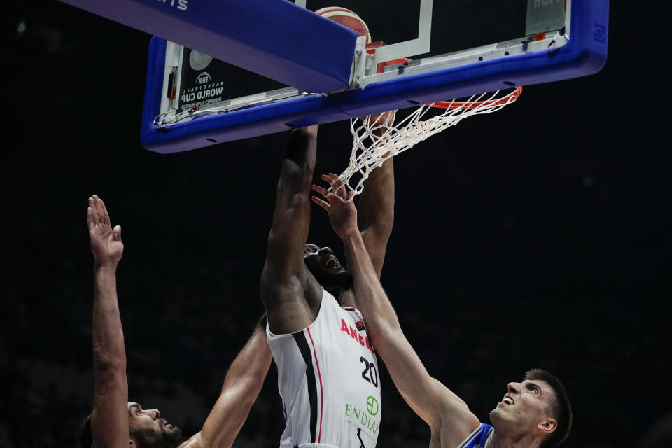 Angola center Bruno Fernando (20) shoots the ball against Italy forward Luca Severini (40) during their match at the Basketball World Cup at the Philippine Arena in Bulacan province, Philippines Friday, Aug. 25, 2023. (AP Photo/Aaron Favila)