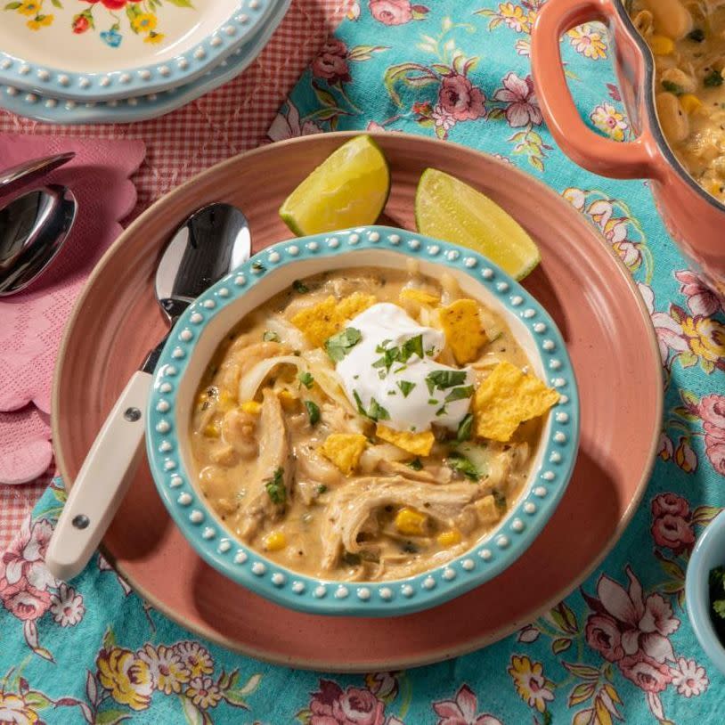 white chicken chili in blue bowl with sour cream and chips