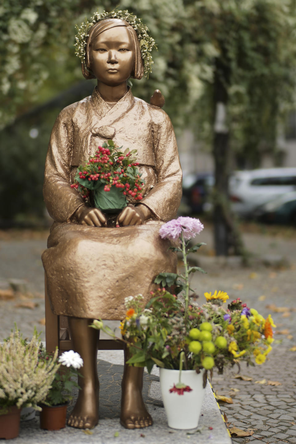 A statue commemorating so-called 'comfort women', an euphemism given by Japan to the women and girls enslaved for sex by the Japanese army during World War II, is displayed at a residential area in central Berlin, Germany, Friday, Oct. 9, 2020. (AP Photo/Markus Schreiber)