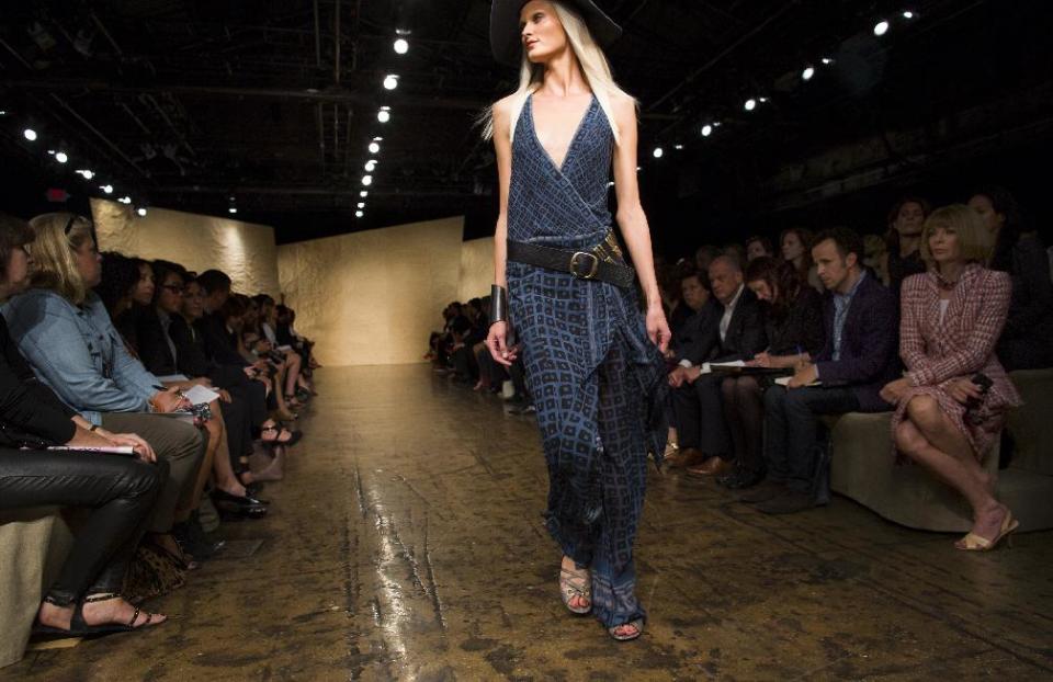 Vogue editor Anna Wintour, seated right, looks on as the Donna Karan Spring 2014 collection is modeled during Fashion Week in New York, Monday, Sept. 9, 2013. (AP Photo/Craig Ruttle)