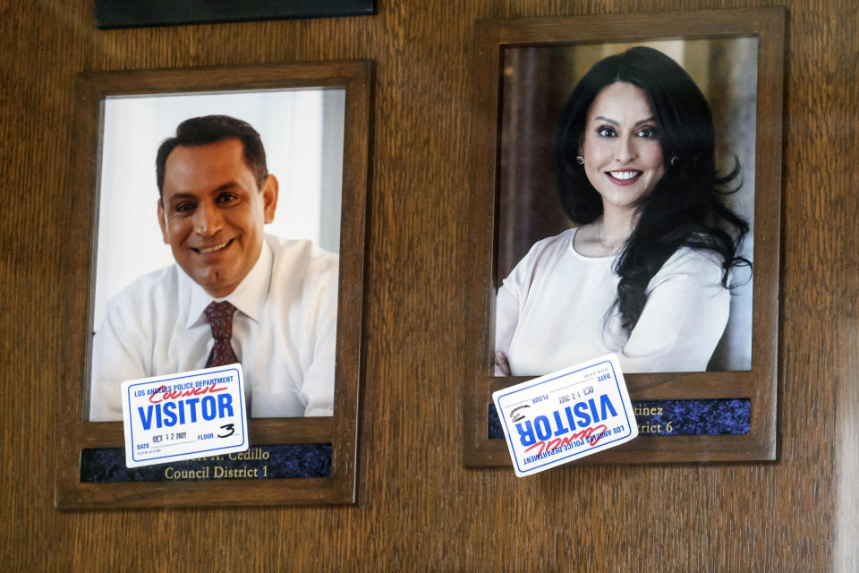 FILE - Stickers are placed on the pictures of Los Angeles Council members Gil Cedillo, left, and Nury Martinez near the entrance of the John Ferraro Council Chamber on Oct. 12, 2022, in Los Angeles. On Oct. 9, a leaked recording revealed Martinez, labor leader Ron Herrera, council members, Kevin de Leon and Cedillo participating in a private meeting in which the Latino Democratic officials made crude, racist remarks and plotted to expand their political power at the expense of Black voters during a realignment of council district boundaries. (AP Photo/Ringo H.W. Chiu, File)
