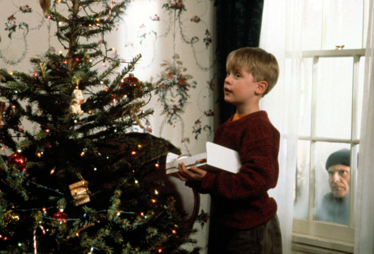 Macaulay Culkin's Kevin decorates a Christmas tree as Joe Pesci's Harry looks on in the 1990 movie 