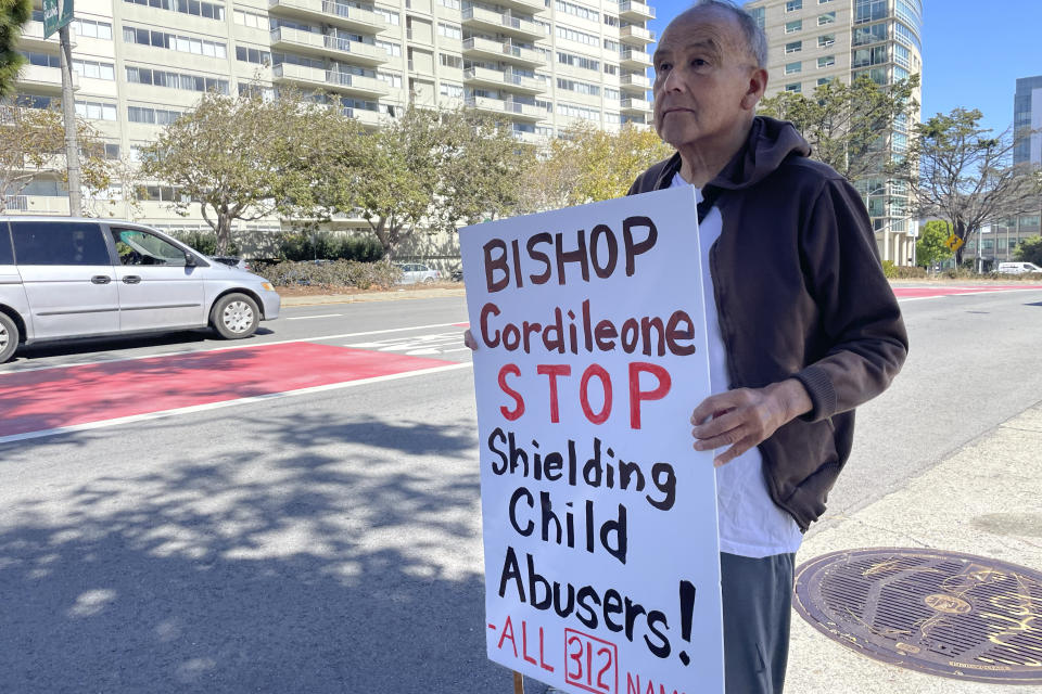 Frank Lostaunau, a member of Northern California SNAP, the Survivors Network of those Abused by Priests, holds a sign as traffic passes outside of St. Mary's Cathedral in San Francisco, Thursday, Sept. 29, 2022. (AP Photo/Haven Daley)