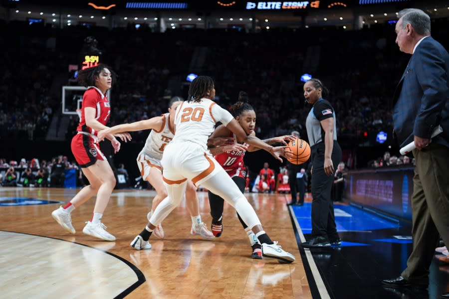North Carolina State guard Aziaha James (10) tries to get around Texas forward Khadija Faye (20) during the first half of an Elite Eight college basketball game in the women’s NCAA Tournament, Sunday, March 31, 2024, in Portland, Ore. Texas coach Vic Schaefer is at right. (AP Photo/Steve Dykes)