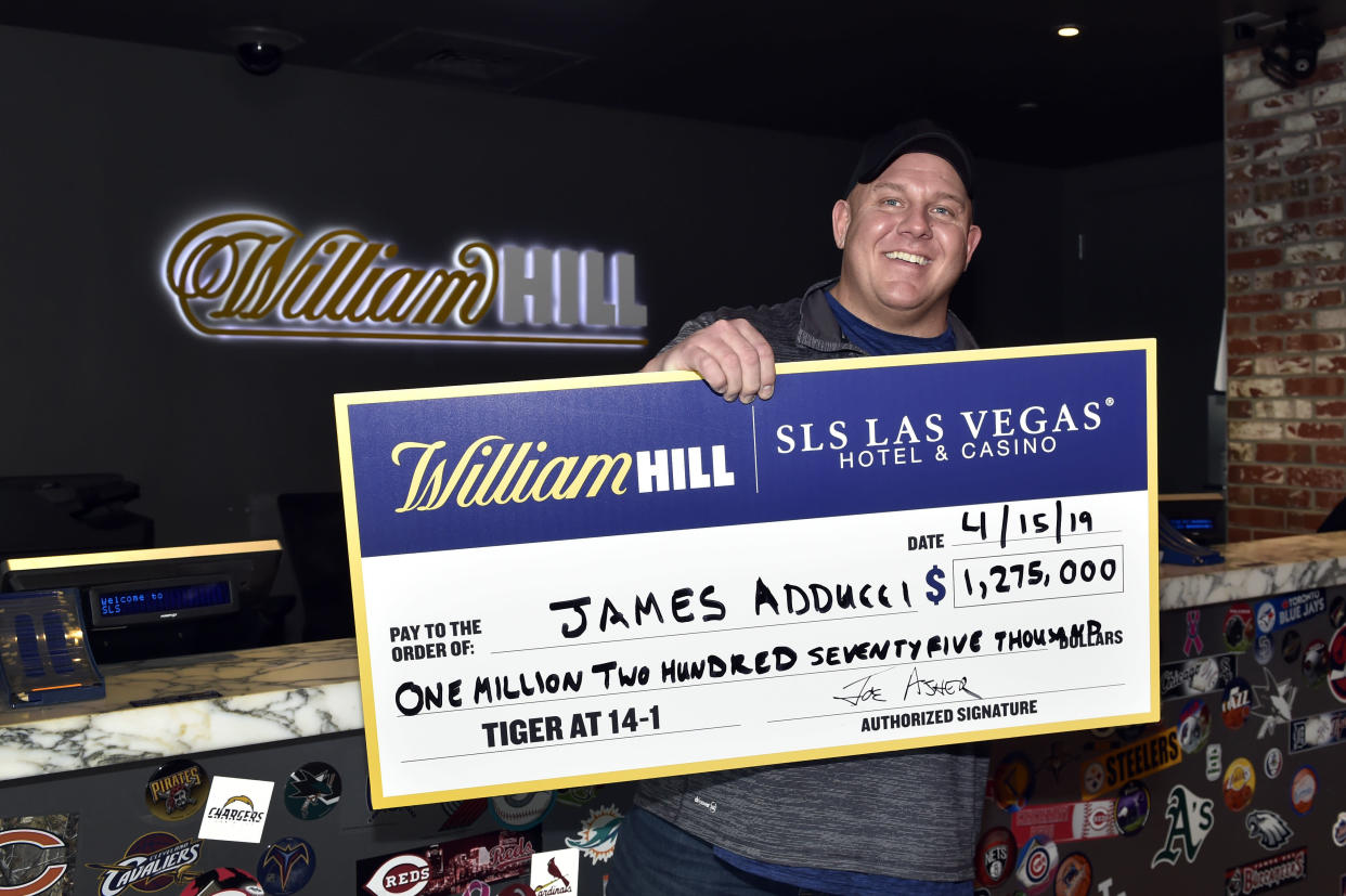 LAS VEGAS, NEVADA - APRIL 15:  James Adducci of Wisconsin stands with a ceremonial check of his winnings after cashing his ticket at the William Hill Sports Book at SLS Las Vegas Hotel on April 15, 2019 in Las Vegas, Nevada. Adducci placed an USD 85,000 wager on golfer Tiger Woods to win the 2019 Masters Tournament.  (Photo by David Becker/Getty Images for William Hill US)