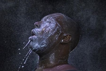 A man is doused with milk and sprayed with mist after being hit by an eye irritant from security forces trying to disperse demonstrators protesting against the shooting of unarmed black teen Michael Brown in Ferguson, Missouri August 20, 2014. REUTERS/Adrees Latif