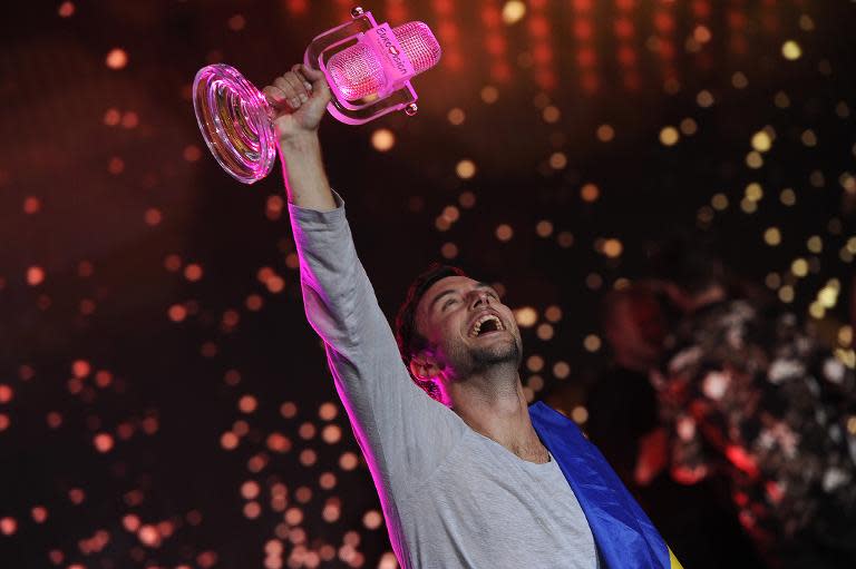 Sweden's Mans Zelmerlow holds the trophy after winning the Eurovision Song Contest final on May 23, 2015 in Vienna