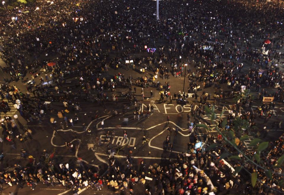 Demonstrators walk around a drawing of an outlined body at Zocalo Square, during a protest in support of 43 missing Ayotzinapa students, in Mexico City