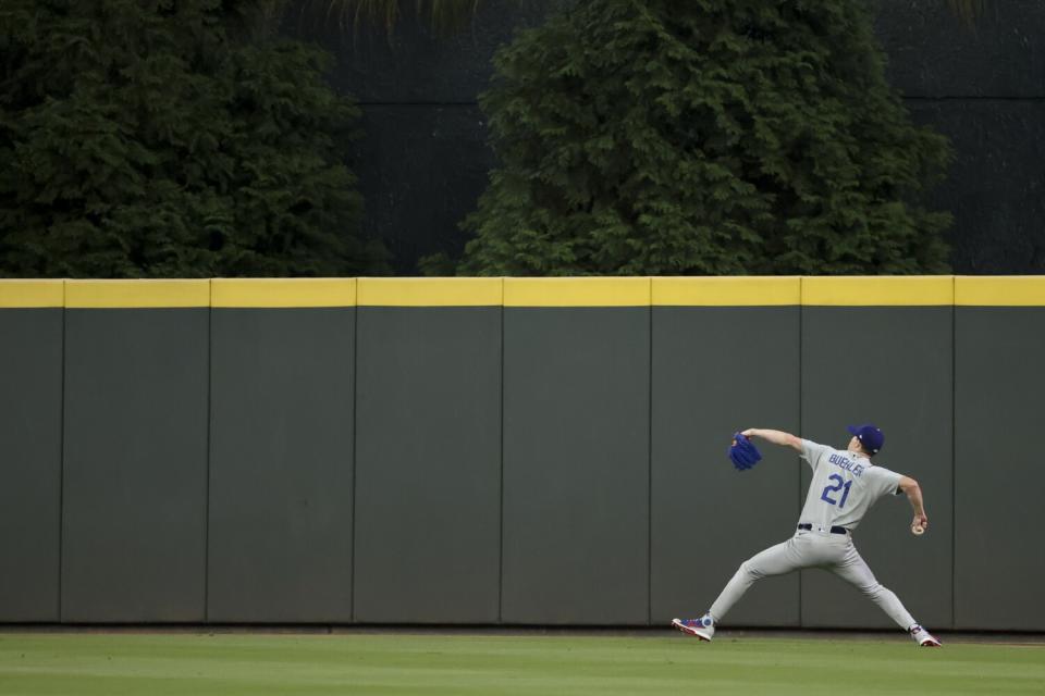 Los Angeles Dodgers starting pitcher Walker Buehler warms up in the outfield.