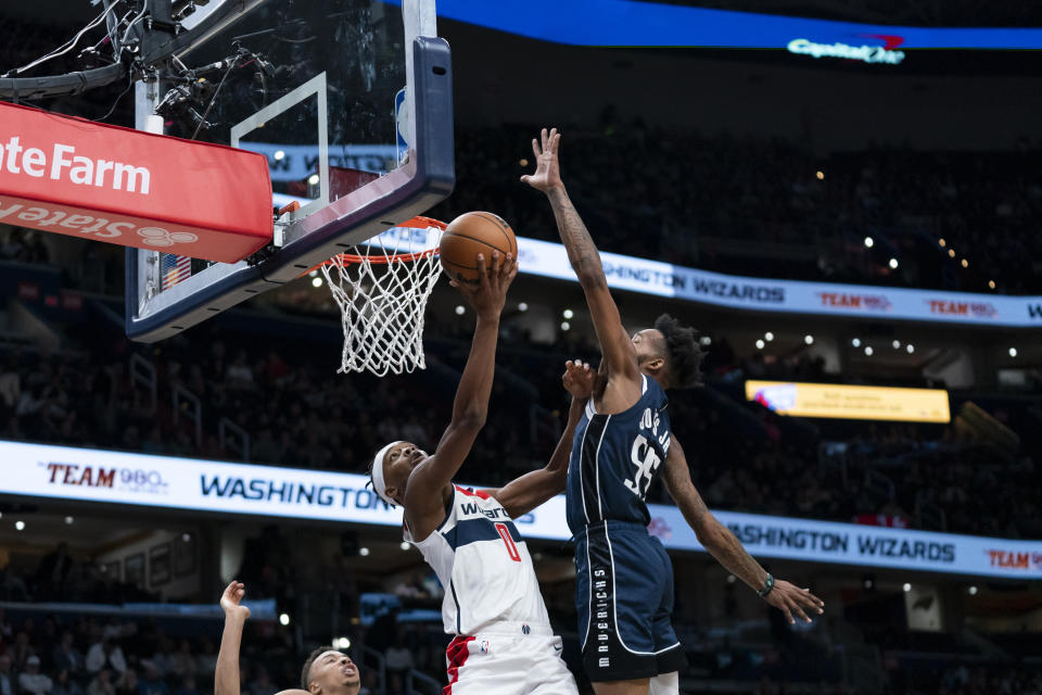 Washington Wizards guard Bilal Coulibaly (0) shoots against Dallas Mavericks forward Derrick Jones Jr. (55) during the first half of an NBA basketball game Wednesday, Nov. 15, 2023, in Washington. (AP Photo/Stephanie Scarbrough)