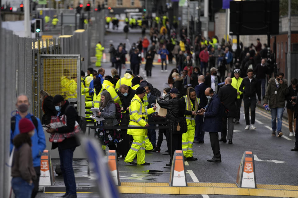 People are security and COVID checked at an the entrance to the COP26 U.N. Climate Summit in Glasgow, Scotland, Sunday, Oct. 31, 2021. The U.N. climate summit in Glasgow formally opens Sunday, a day before leaders from around the world gather in Scotland's biggest city to lay out their vision for addressing the common challenge of global warming. (AP Photo/Alastair Grant)