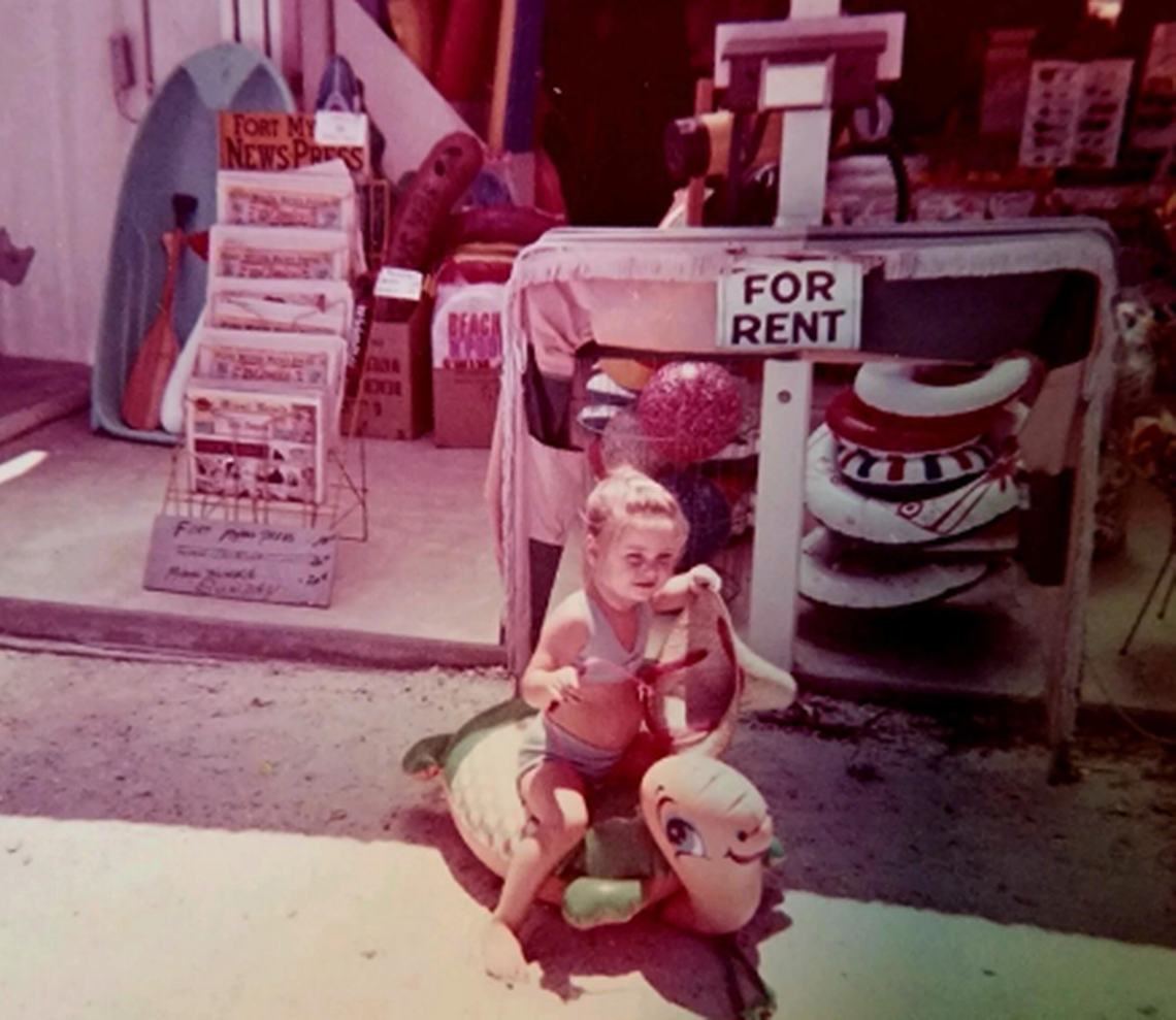 Kimberly Sanders on a floaty outside of her grandmother’s surf shop, Edna Mae’s Surf Shop, on Fort Myers Beach. The structure was destroyed by Hurricane Ian.