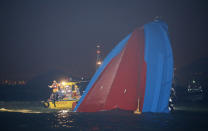 Rescuers check on a half submerged boat after it collided Monday night near Lamma Island, off the southwestern coast of Hong Kong Island Tuesday, Oct. 2, 2012. Authorities in Hong Kong have rescued 101 people after a ferry collided with a tugboat and sank. A local broadcaster says eight people died. (AP Photo/Kin Cheung)