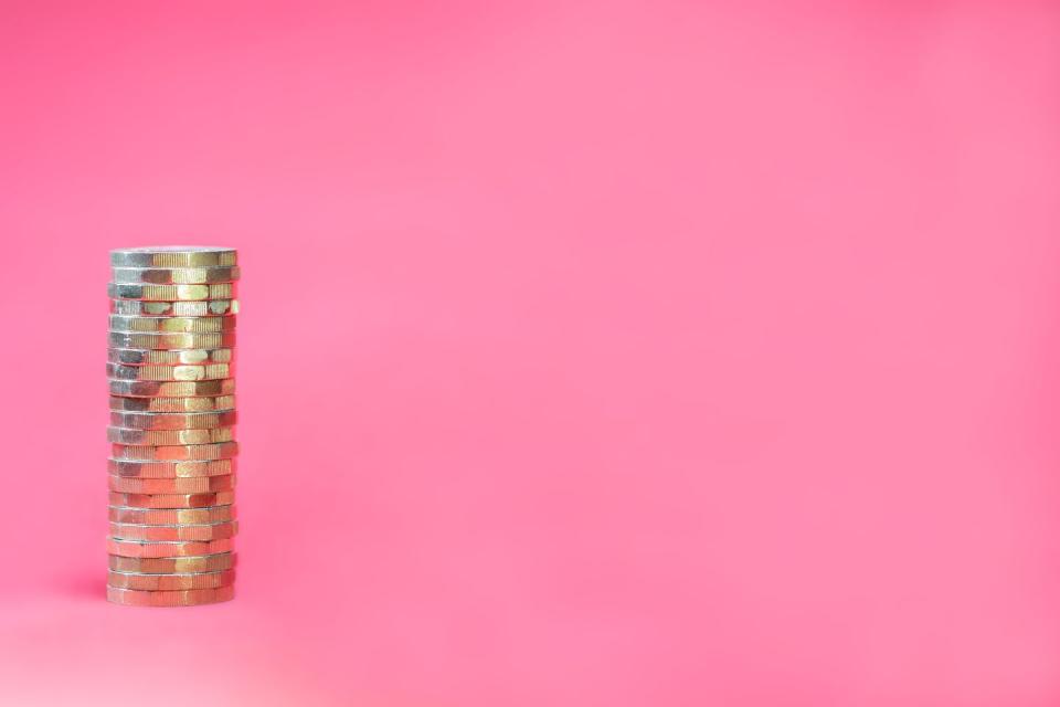 stacked pound coins on a pink background