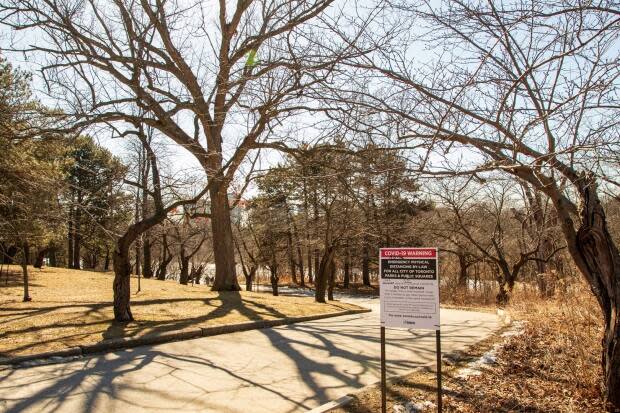 City signs in High Park asking for mask wearing and social distancing to slow the spread of COVID-19. The city hasn't released any plans and can't confirm whether or not it will close the park for the blooming season this year.  ((c) Copyright Steven Joniak Photography - image credit)