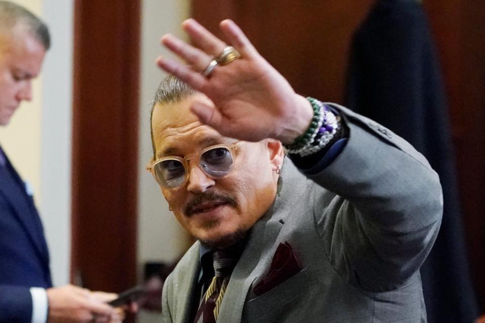 Johnny Depp waves to the courtroom gallery (AP)