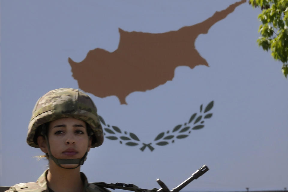 A famale Cypriot soldier stands on a truck during a military parade marking the 62nd anniversary of Cyprus' independence from British colonial rule, in Nicosia, Cyprus, Saturday, Oct. 1, 2022. Cyprus gained independence from Britain in 1960 but was split along ethnic lines 14 years later when Turkey invaded following a coup aimed at uniting the island with Greece. (AP Photo/Petros Karadjias)