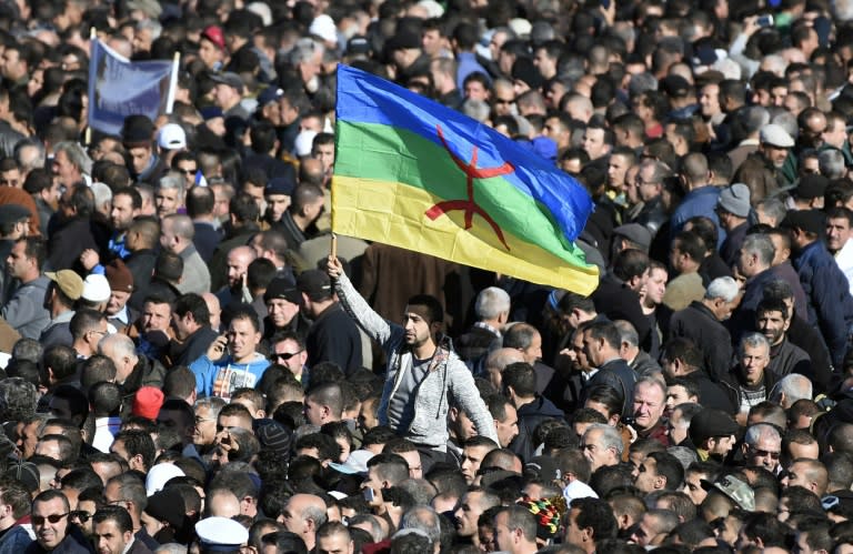 A man waves the Amazigh flag at the funeral in Ait Ahmed village on January 1, 2016 of Hocine Ait-Ahmed, a fathers of Algeria's struggle for independence and a key opposition figure