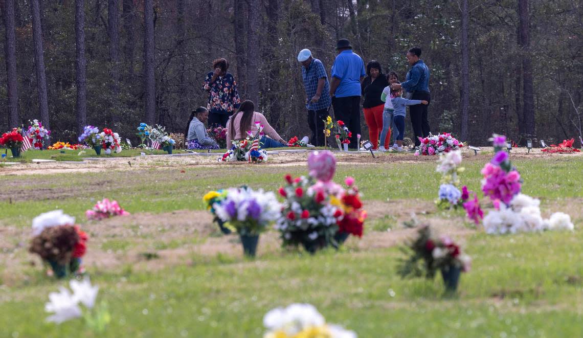 Mourners visit a gravesite at the Sandhills State Veterans Cemetery in Spring Lake Tuesday, Feb 21, 2022. North Carolina’s four state-owned veterans cemeteries are behind on maintenance and are short-staffed.
