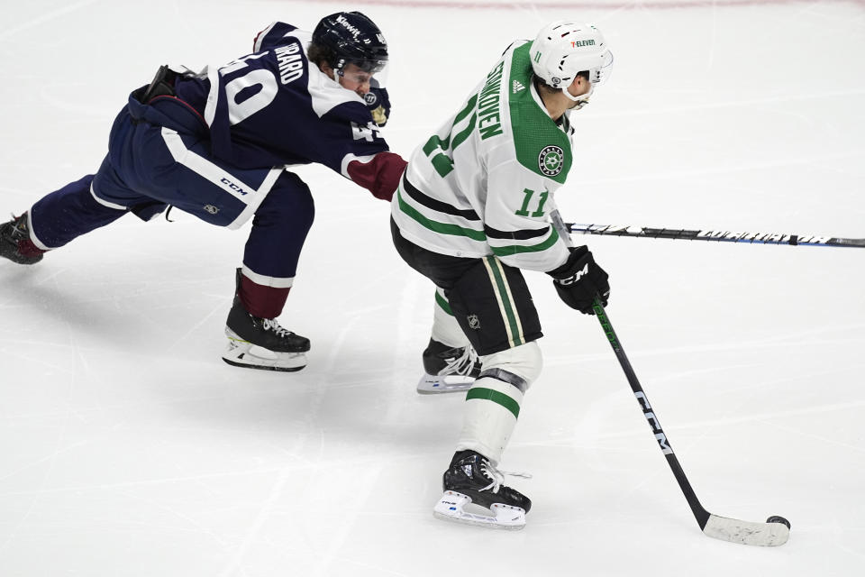 Dallas Stars center Logan Stankoven (11) looks to shoot the puck as Colorado Avalanche defenseman Samuel Girard covers in the third period of an NHL hockey game Sunday, April 7, 2024, in Denver. (AP Photo/David Zalubowski)