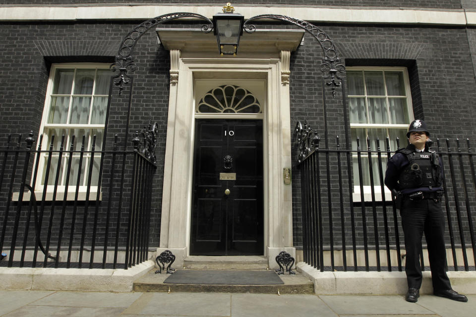 A police officer stands outside the front door of number 10, Downing Street, London, Wednesday, May 5, 2010, the day before Britain goes to the polls in a General Election. With polls still indicating that Britain is on course for a hung parliament, all three major party leaders were engaged in frenzied last-ditch campaigning across the country. (AP Photo/Matt Dunham)