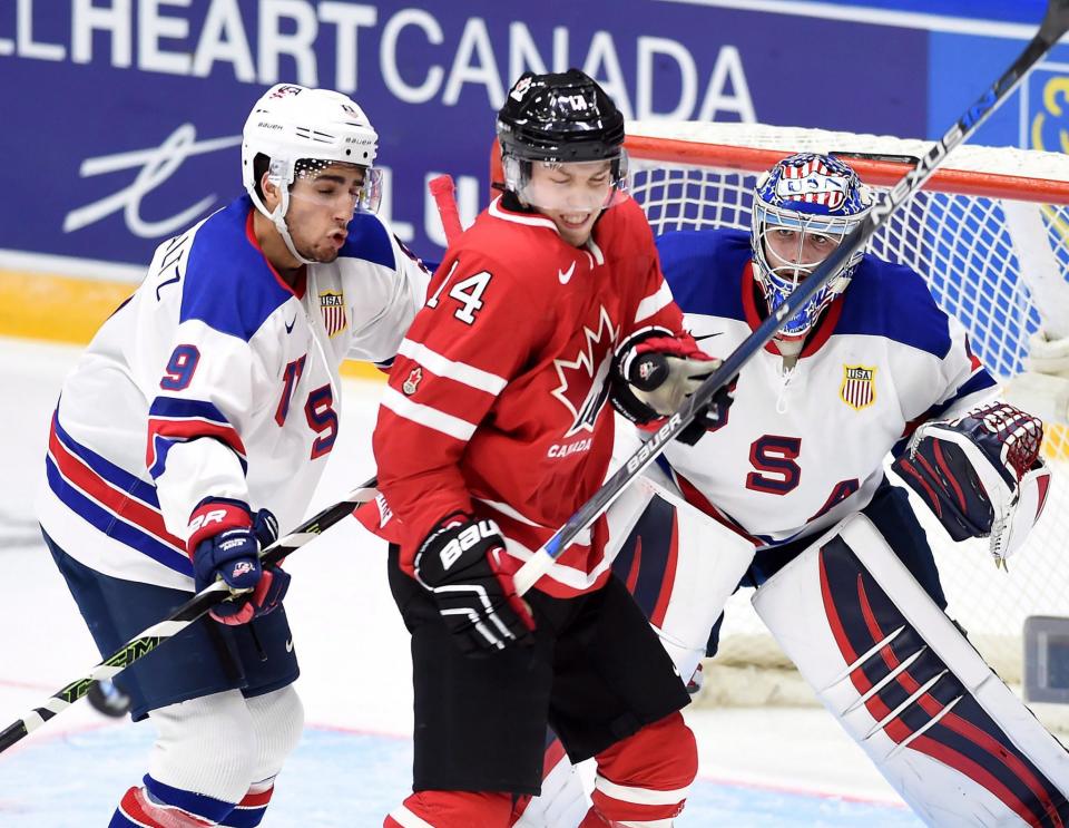 Canada's Rourke Chartier (14) takes a shot from a teammate as the United States' Nick Schmaltz (9) tries to check him away from the crease during the 2016 world junior championship in Helsinki, Finland. (THE CANADIAN PRESS)