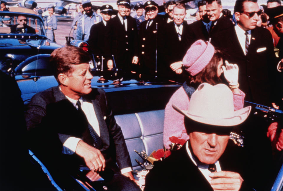 John and Jackie Kennedy with John Connally in automobile.