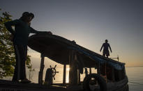 Fishermen walk on their boat as they fish in the Tapajos river in Alter do Chao, district of Santarem, Para state, Brazil, Thursday, Aug. 27, 2020. Last year a massive fire, whose origins are still under investigation, destroyed an area equivalent to 1,600 soccer fields in Alter do Chão. (AP Photo/Andre Penner)