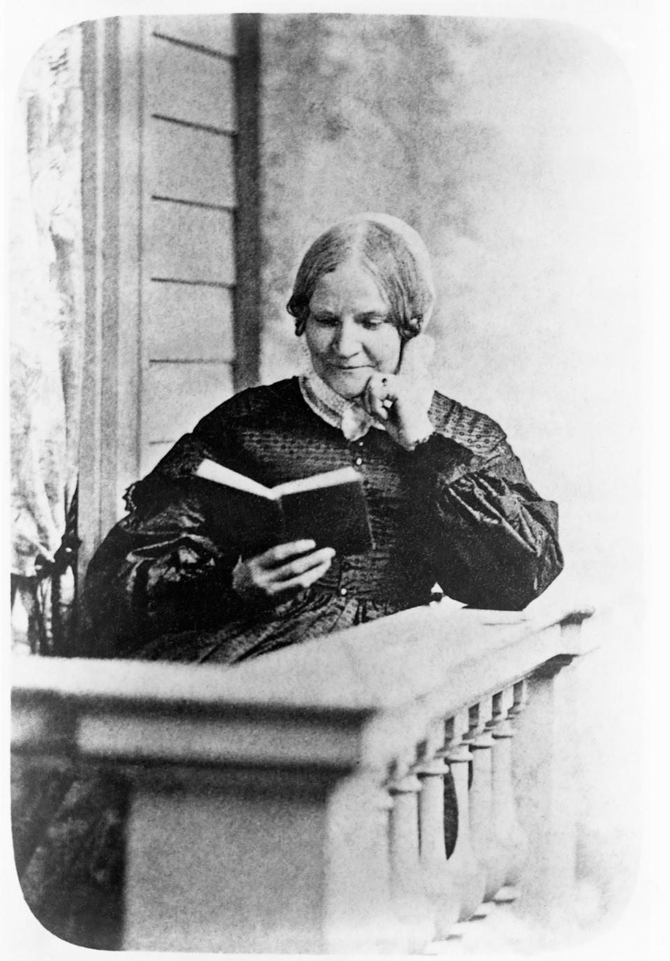 Lydia Maria Child (1802-1880) reads a book on a front porch. Child wrote and edited books promoting the suffragist and abolitionist causes. | Corbis/Getty Images