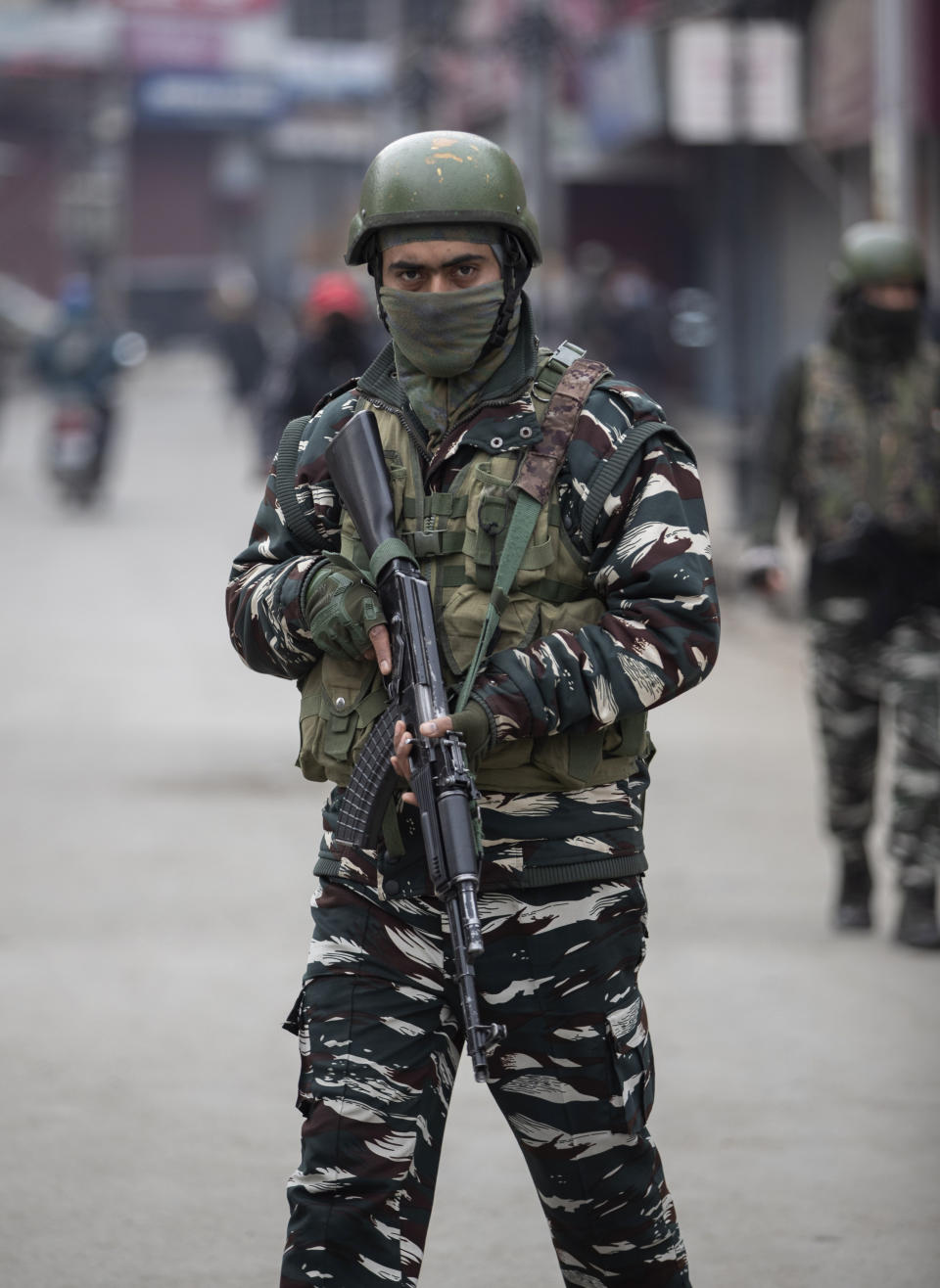Indian paramilitary soldiers patrol through a closed market in Srinagar, Indian controlled Kashmir, Tuesday, Feb. 9, 2021. Businesses and shops have closed in many parts of Indian-controlled Kashmir to mark the eighth anniversary of the secret execution of a Kashmiri man in New Delhi. Hundreds of armed police and paramilitary soldiers in riot gear patrolled as most residents stayed indoors in the disputed region's main city of Srinagar. (AP Photo/Mukhtar Khan)