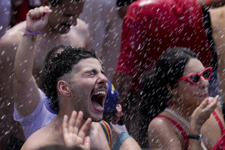 Firefighters spray water over supporters of Luiz Inacio Lula da Silva gathering to attend his inauguration as new president outside the Planalto presidential palace in Brasilia, Brazil, Sunday, Jan. 1, 2023. (AP Photo/Silvia Izquierdo)