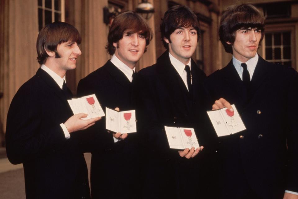26th October 1965: British pop group The Beatles, from left to right; Ringo Starr, John Lennon (1940 - 1980), Paul McCartney and George Harrison (1943 - 2001), outside Buckingham Palace, London, after receiving their MBE's (Member of the Order of the British Empire) from the Queen. (Photo by Fox Photos/Getty Images)
