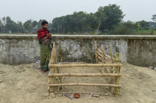 Mukul Seikh praying in front of the grave of his mother, former sex worker Hamida Begum