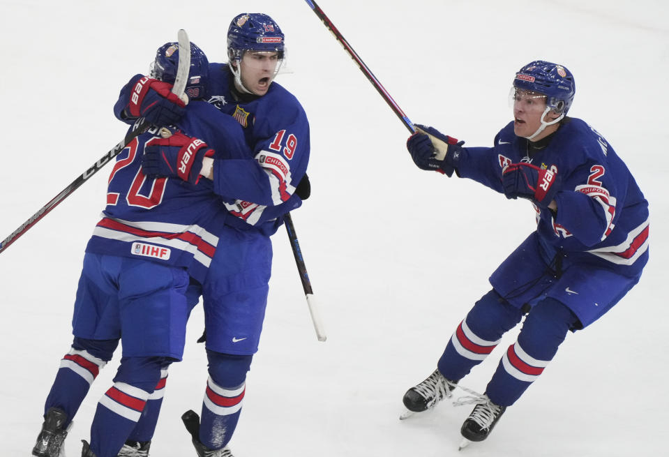 Team USA's Cutter Gauthier (19) celebrates after his winning goal over Finland with teammates Lane Hutson (20) and Rutger McGroarty (2) during third-period semifinal game action at the IIHF World Junior Hockey Championship in Gothenburg, Sweden, Thursday, Jan. 4, 2024. (Christinne Muschi/The Canadian Press via AP)