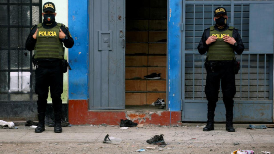 Police officers stand guard outside the Thomas Restobar club in Lima's Los Olivos district. Source: Reuters