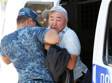 A law enforcement officer detains a man during an anti-government protest in Almaty