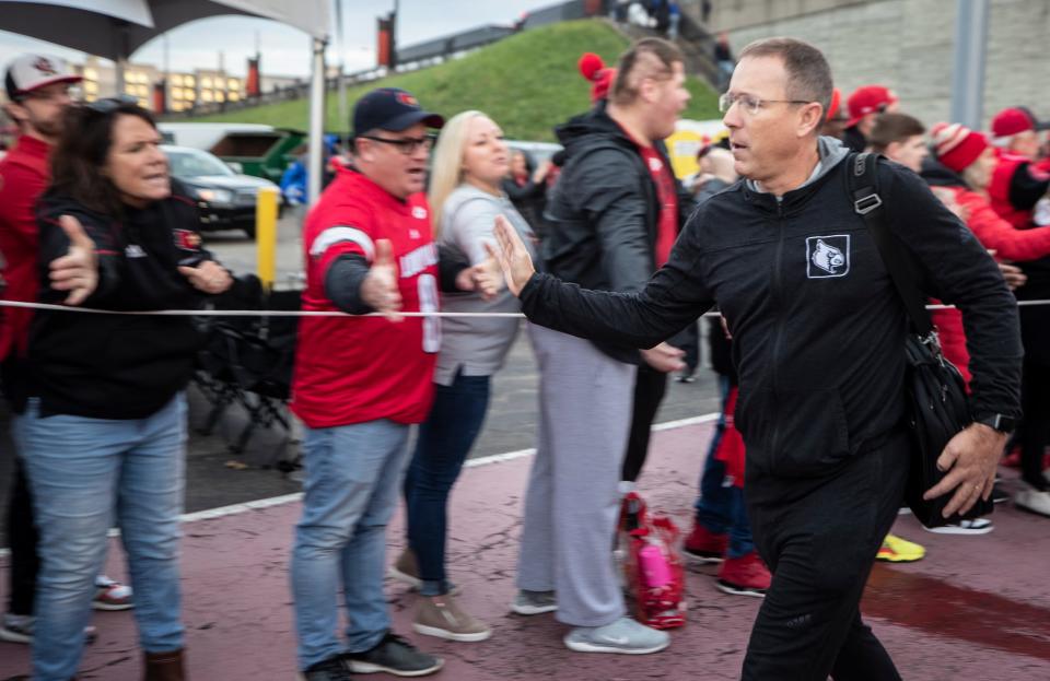 Louisville coach Scott Satterfield hi fives with a fan during the Card March prior to the Governor's Cup game against Kentucky at Cardinal Stadium. Nov 27, 2021