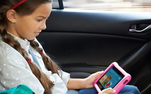 Kid in a car watching a cartoon on a tablet - Credit: Amazon