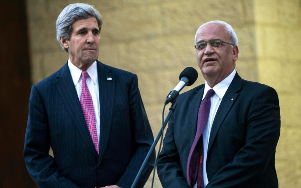 File image from 2014 where US Secretary of State John Kerry, left, listens to Palestinian negotiator Saeb Erekat - Brendan Smialowski/ AFP