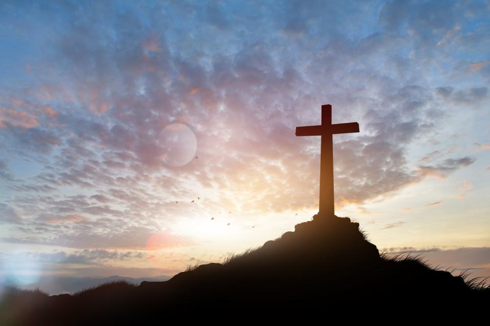 cross on blurry sunset background