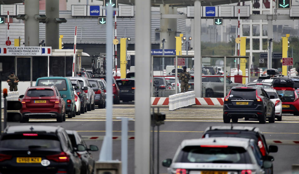 People queue in line to check-in for the Euro Tunnel train to the U.K. in Coquelles, France, Friday Aug.14, 2020. British holiday makers in France were mulling whether to return home early Friday to avoid having to self-isolate for 14 days following the U.K. government's decision to reimpose quarantine restrictions on France amid a recent pick-up in coronavirus infections. (AP Photo/Olivier Matthys)