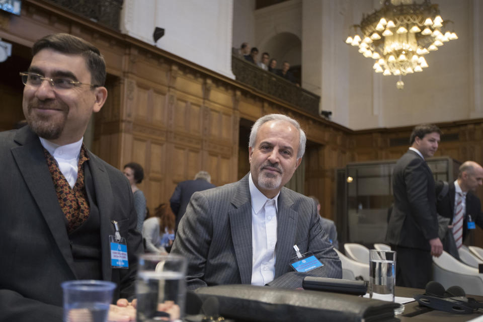 Mohammed Zahedin Labbaf, center, agent for the Islamic Republic of Iran, waits for judges to enter, as the U.S. delegation is seen rear right, at the International Court of Justice, or World Court, in The Hague, Netherlands, Wednesday, Oct. 3, 2018, where judges ruled on an Iranian request to order Washington to suspend sanctions against Tehran. (AP Photo/Peter Dejong)