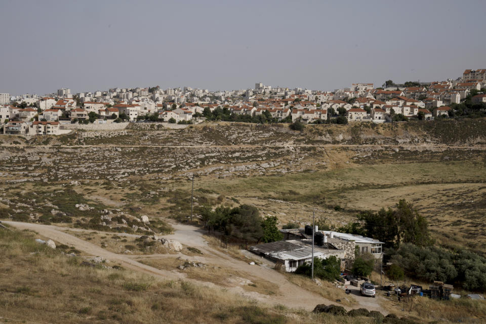 A Palestinian home sits in a valley, located next to the east Jerusalem Israeli settlement of Pisgat Ze'ev, Thursday, May 12, 2022. Israel advanced plans for the construction of more than 4,000 settler homes in the occupied West Bank on Thursday, a rights group said, a day after the military demolished homes in an area where hundreds of Palestinians face the threat of expulsion. (AP Photo/Maya Alleruzzo)
