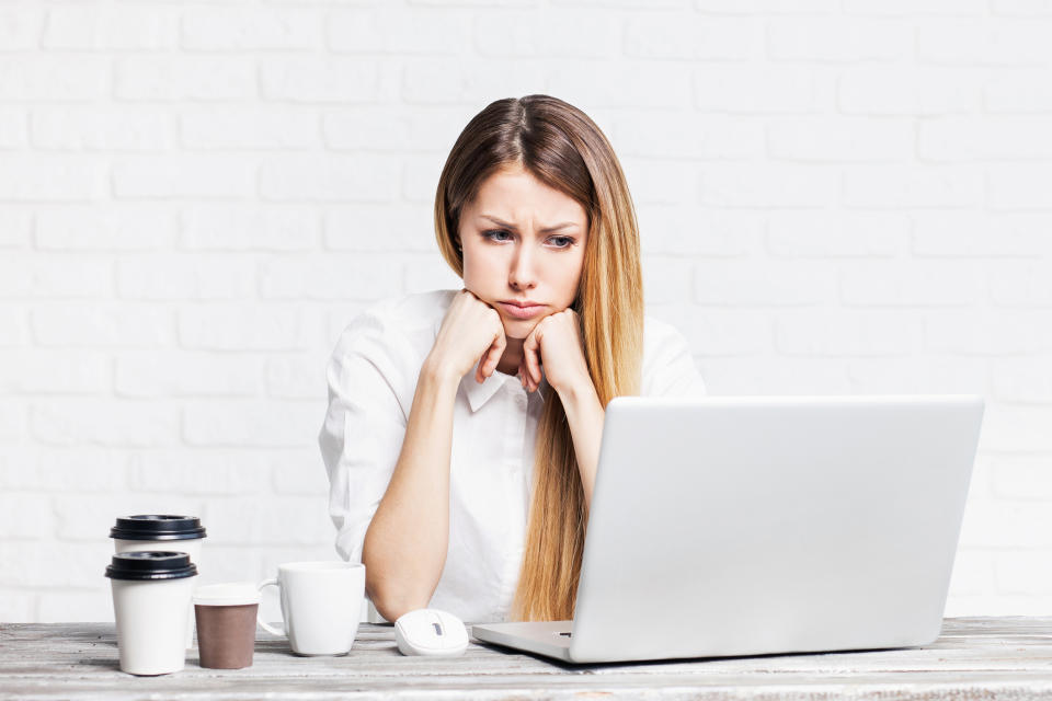 Woman staring at laptop with sad expression