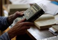 Petr Brandejsky, a 90-year-old Holocaust survivor, holds a book at his apartment in Prague